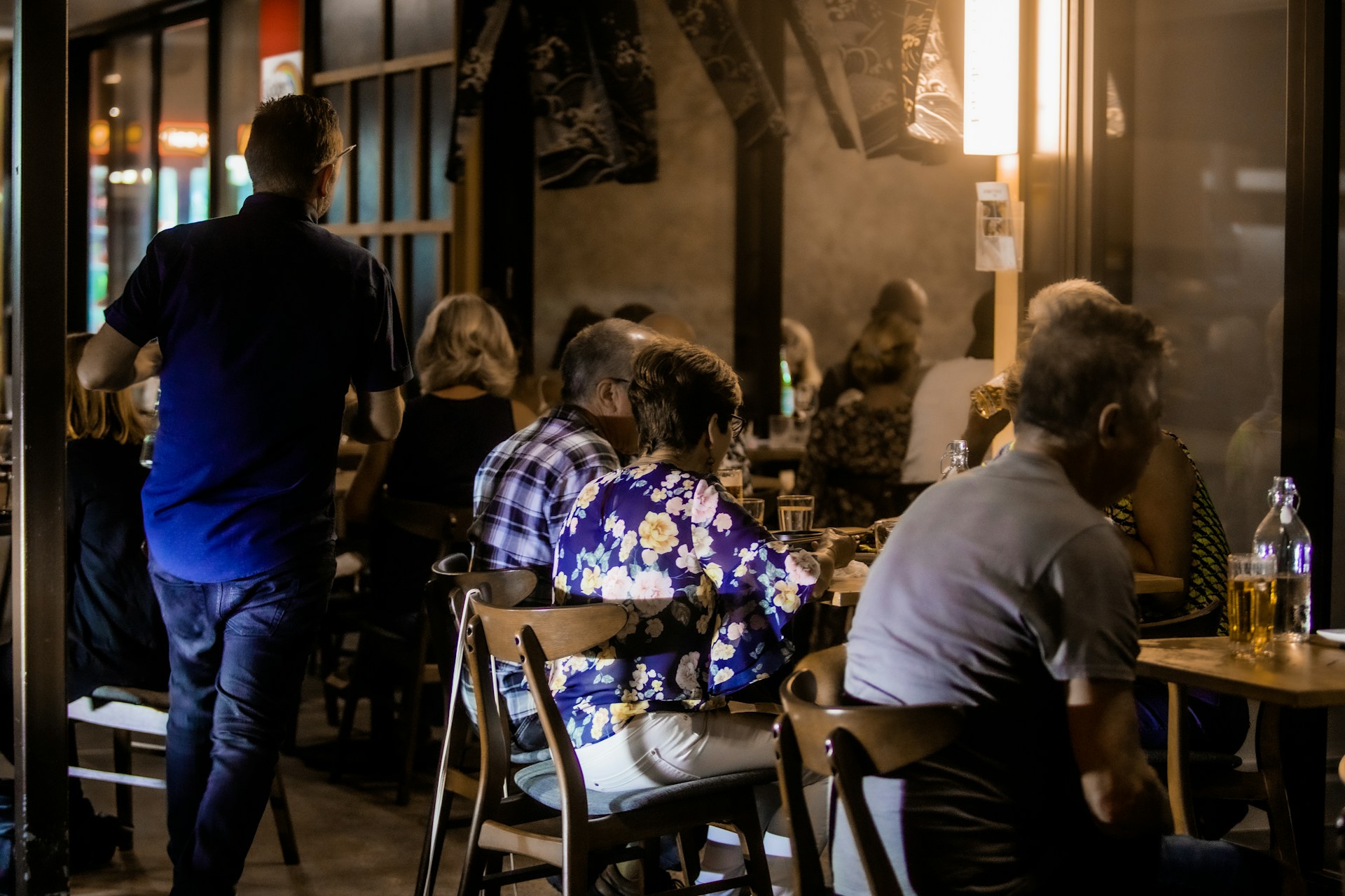 the inside of a restaurant where people are speaking across the table