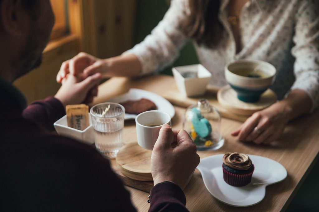 a couple enjoying a coffee and snacks in a coffee shop