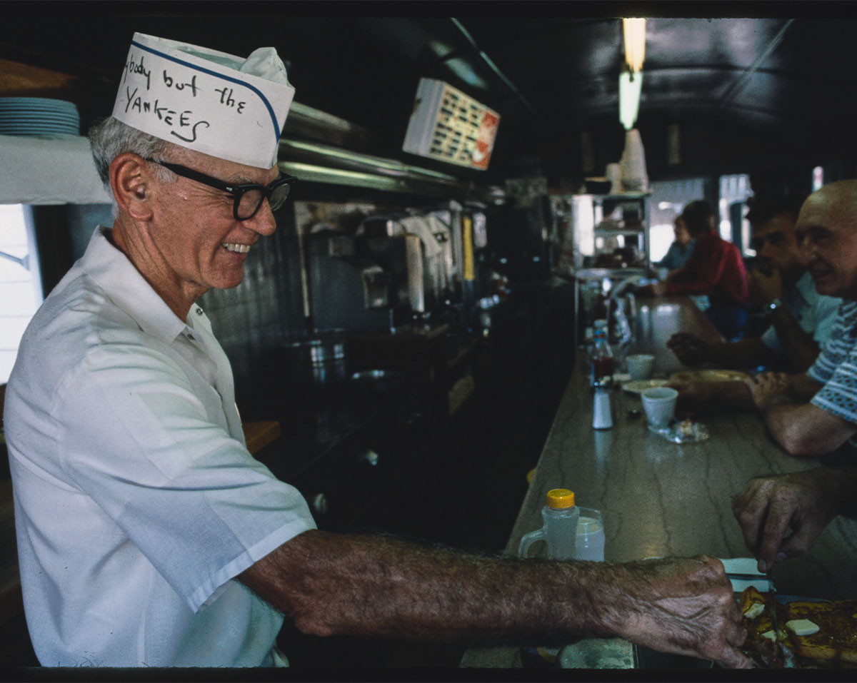 An old man serving cafe in a brunch spot.